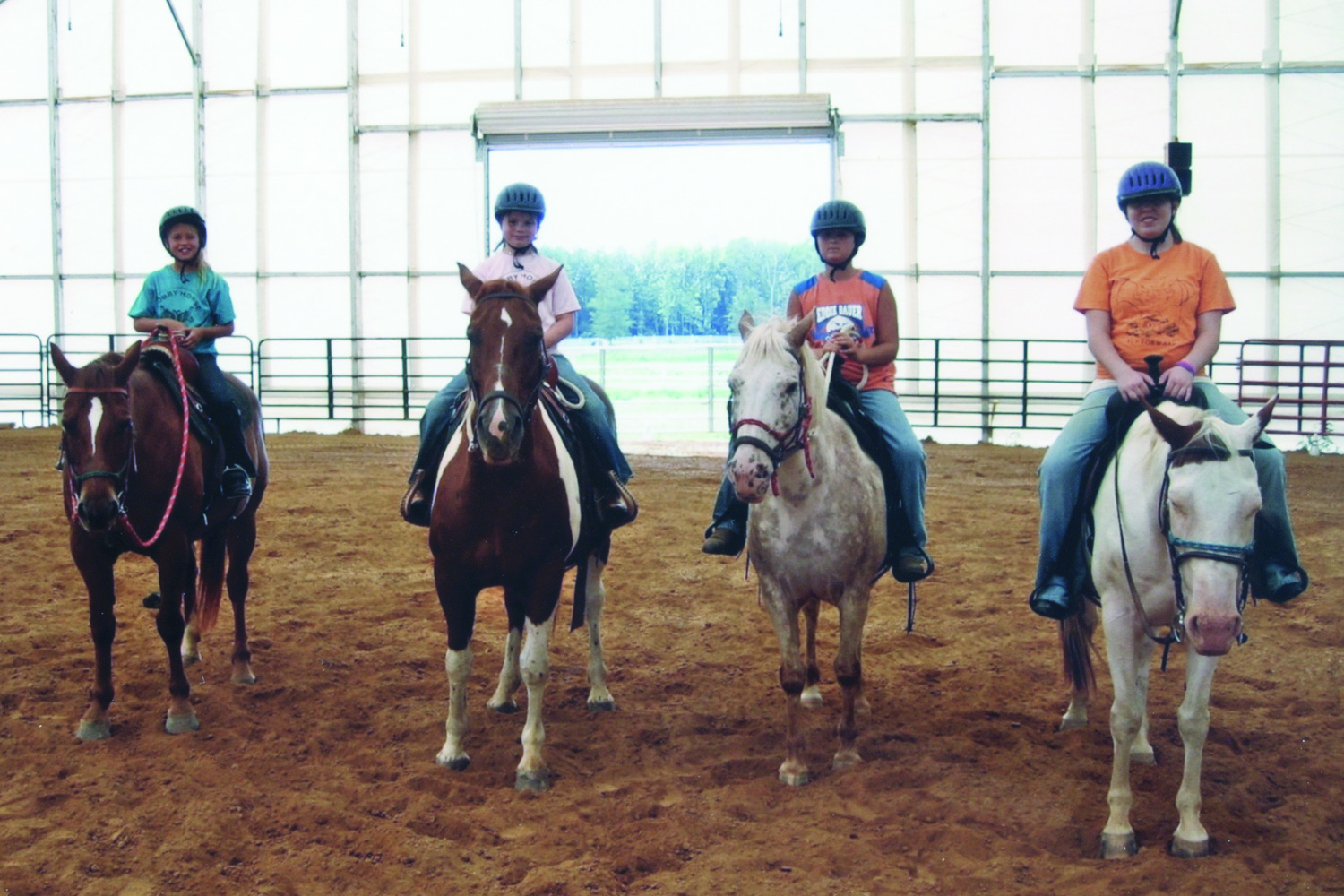 Family Riding Horses in a Fabric Structure