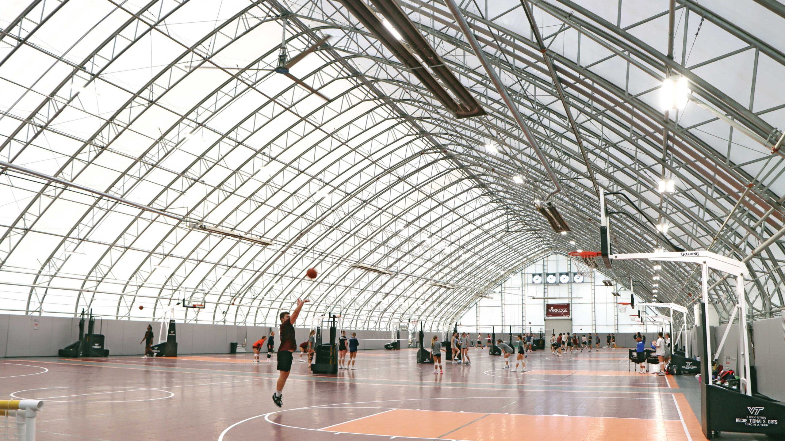 Inside of recreational building with basketball and volleyball courts